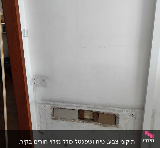 קיר לבן עם חור ותיקונים, דלי צבע ירוק